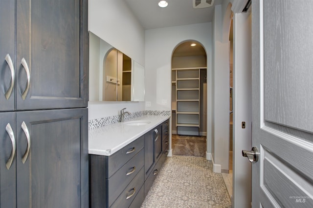 bathroom featuring a spacious closet, tile patterned flooring, vanity, and baseboards