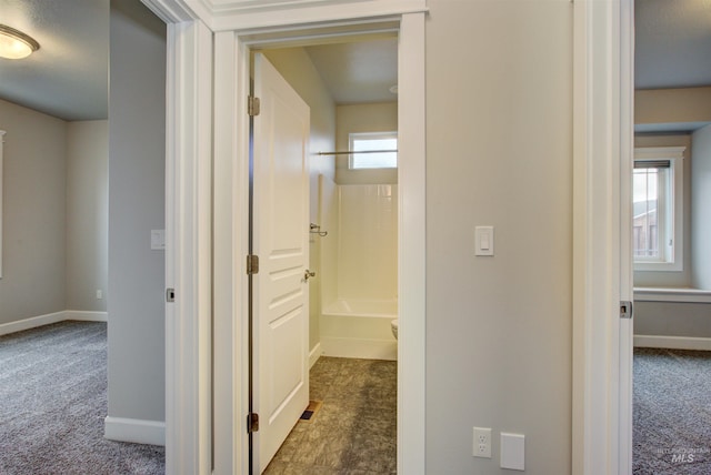 hallway with baseboards and carpet floors