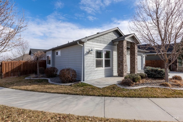 view of side of property with a garage, a patio, and fence