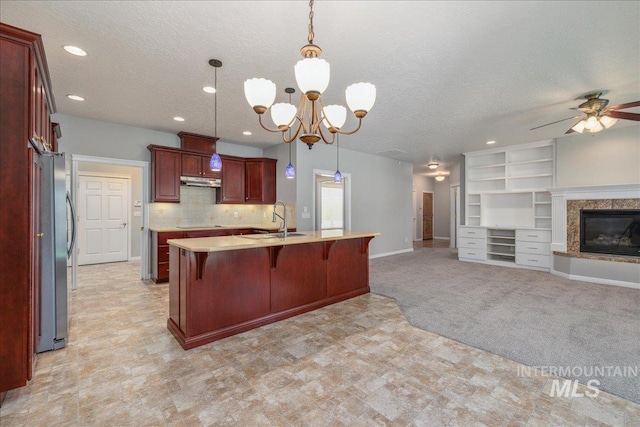 633 S Archstone Way, Boise, ID 83709 - kitchen featuring freestanding refrigerator, dark brown cabinets, light countertops, open floor plan, and a kitchen breakfast bar