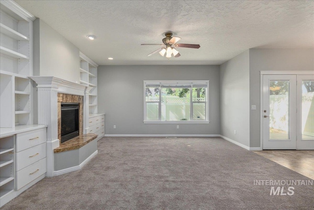 633 S Archstone Way, Boise, ID 83709 - unfurnished living room with carpet floors, ceiling fan, a tiled fireplace, a textured ceiling, and built in features