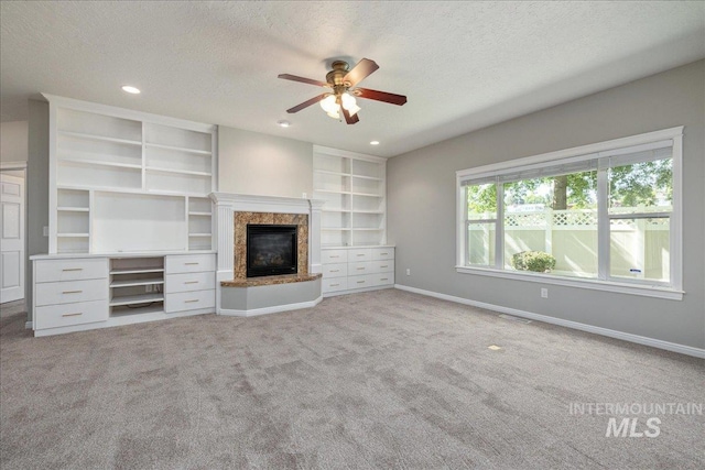 633 S Archstone Way, Boise, ID 83709 - unfurnished living room featuring a ceiling fan, a textured ceiling, light carpet, a high end fireplace, and recessed lighting