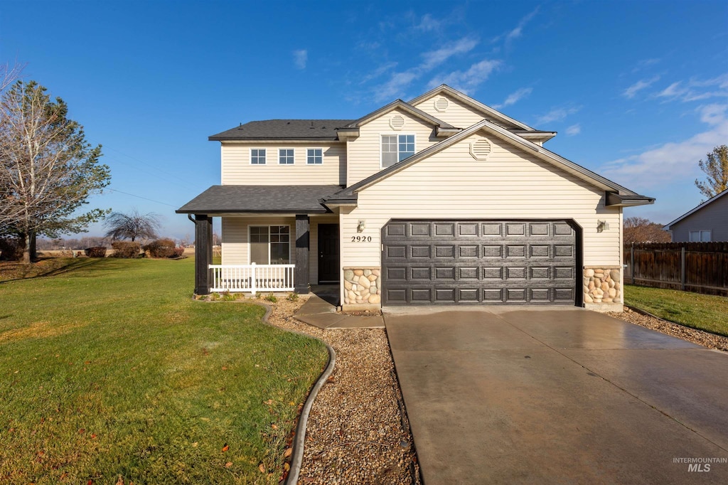 view of front of house featuring a front yard, a garage, and covered porch