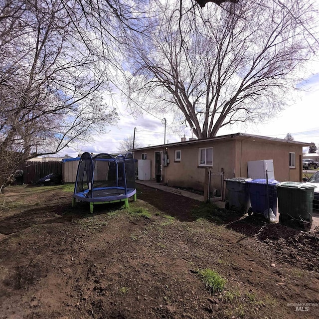 view of yard with a trampoline and fence