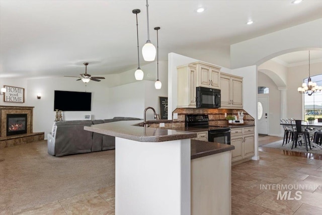 kitchen with cream cabinetry, decorative light fixtures, tasteful backsplash, and black appliances