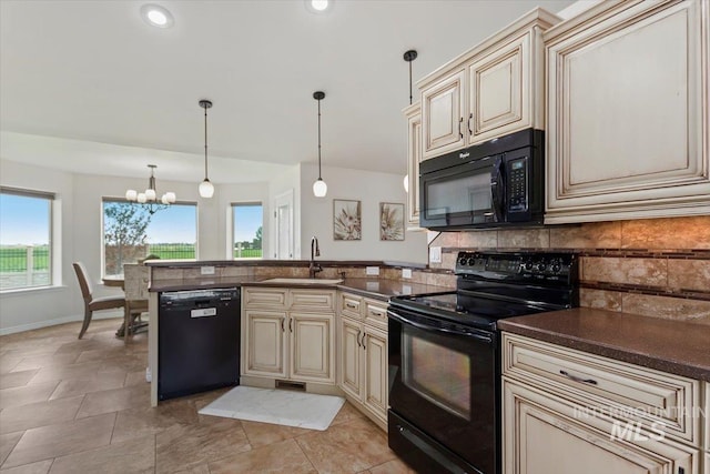 kitchen with cream cabinets, sink, black appliances, and decorative light fixtures