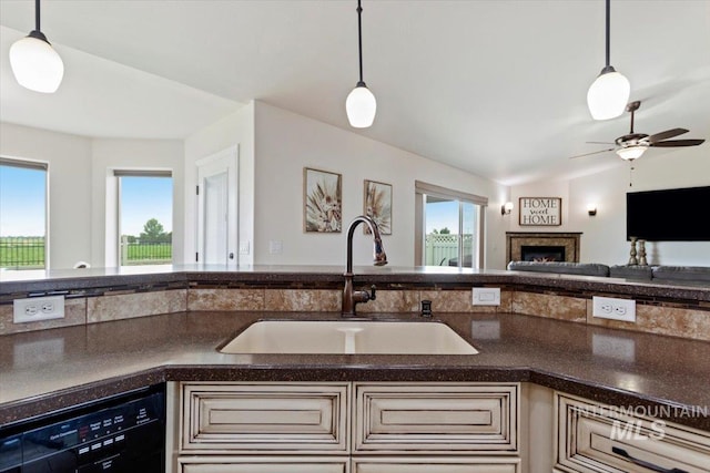 kitchen featuring dishwasher, lofted ceiling, sink, and hanging light fixtures