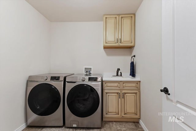 washroom featuring cabinets, sink, and washing machine and clothes dryer