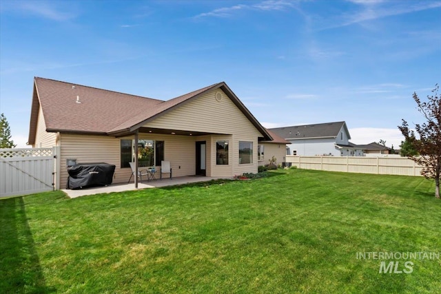 rear view of house featuring a yard and a patio area