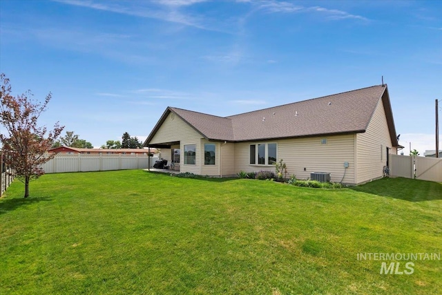 rear view of house with a yard and central AC unit