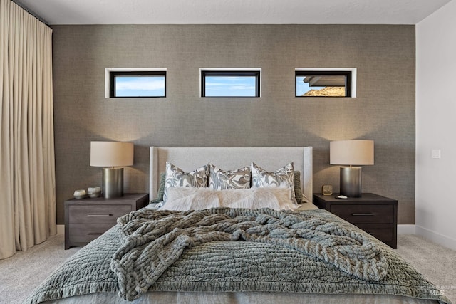 bedroom featuring light carpet and baseboards