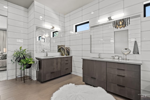 bathroom with two vanities, a sink, and tile walls