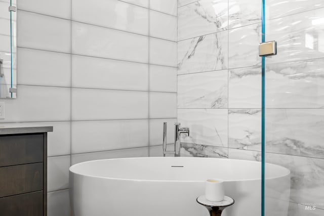 bathroom with a freestanding bath and tile walls