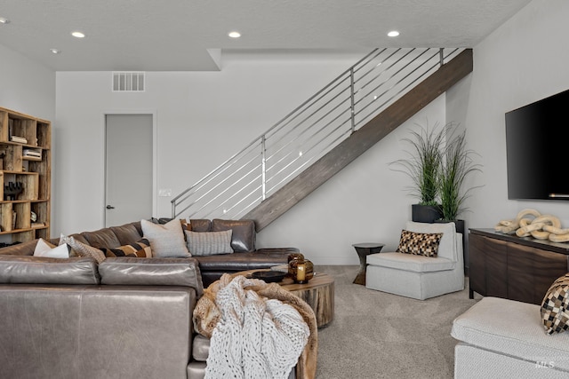 living room with stairway, recessed lighting, visible vents, and light carpet