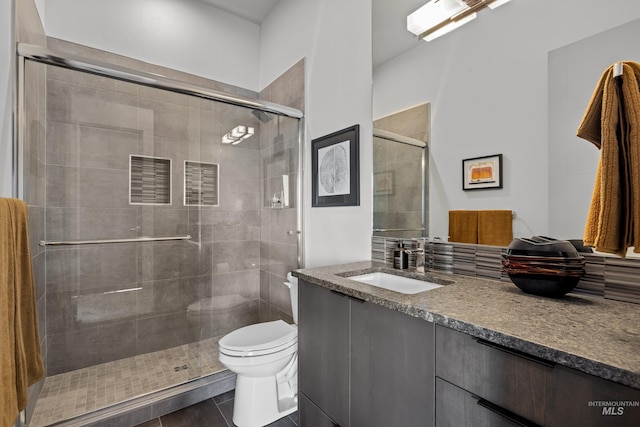 full bath featuring a stall shower, vanity, and toilet