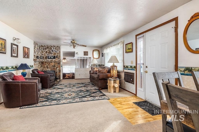 living room featuring a textured ceiling, ceiling fan, and wood finished floors