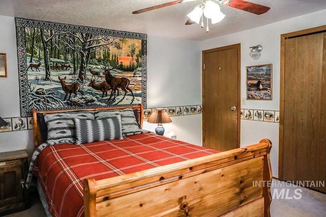 bedroom with a ceiling fan and a textured ceiling