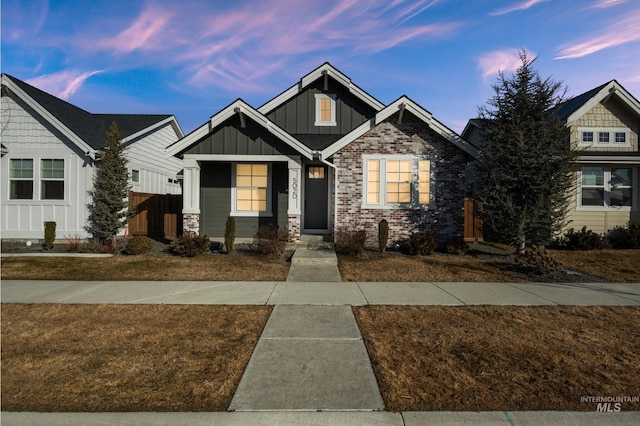 craftsman inspired home featuring brick siding and board and batten siding