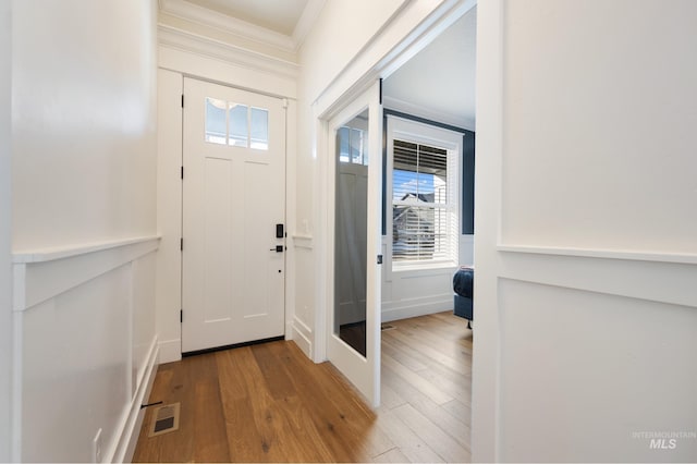 entryway with wood finished floors, visible vents, and a healthy amount of sunlight