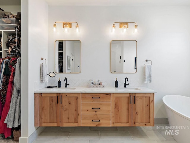 1305 N Big Star Pl, Eagle, ID 83616 - bathroom featuring double vanity, a walk in closet, a freestanding bath, decorative backsplash, and tile patterned flooring