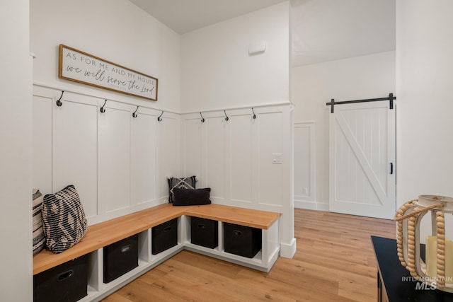 1305 N Big Star Pl, Eagle, ID 83616 - mudroom featuring a decorative wall, light wood-type flooring, wainscoting, and a barn door