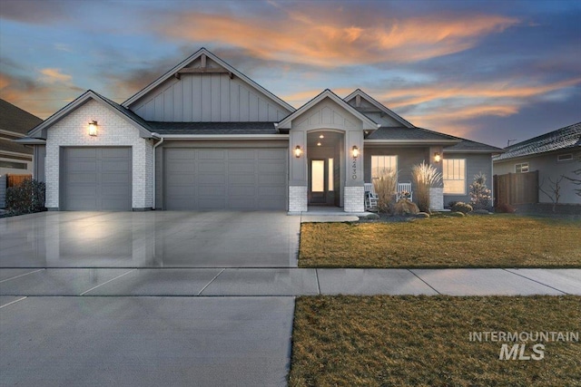 view of front facade featuring concrete driveway, brick siding, an attached garage, a lawn, and board and batten siding