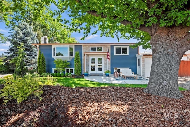 632 N Edgewood Ln, Eagle, ID 83616 - back of house with french doors, a patio area, a chimney, and a garage