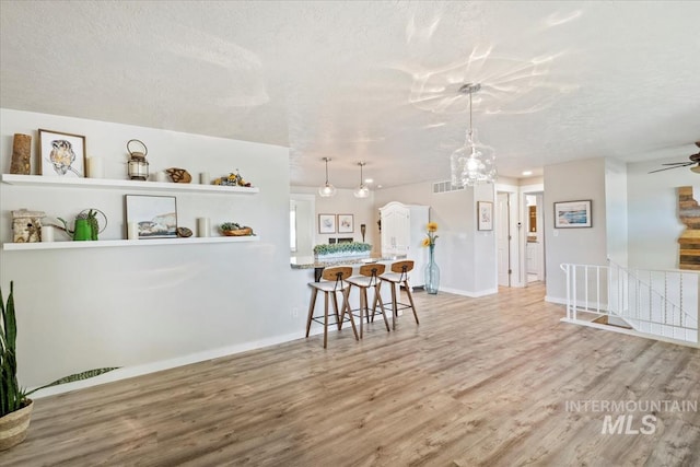 632 N Edgewood Ln, Eagle, ID 83616 - dining area featuring wood finished floors, ceiling fan, a textured ceiling, and a chandelier