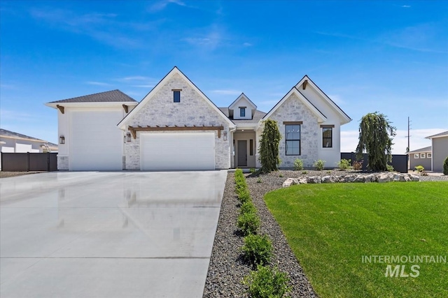 view of front of property featuring a garage, stone siding, driveway, and a front lawn