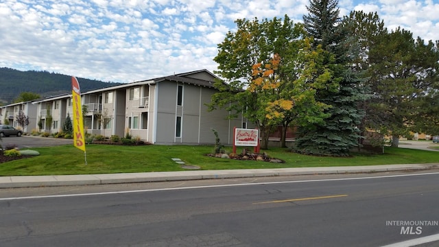 view of front of property with a balcony and a front yard