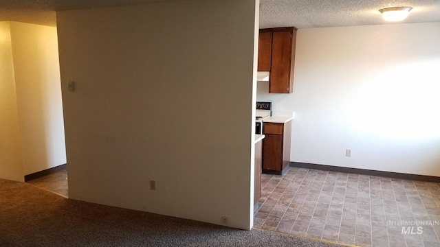 interior space with light colored carpet, a textured ceiling, electric range, and range hood