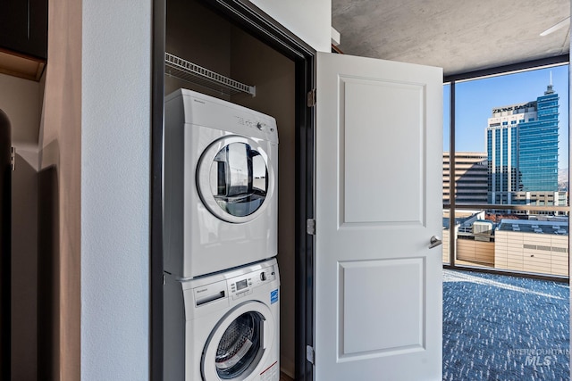 clothes washing area with a view of city, laundry area, and stacked washer / dryer