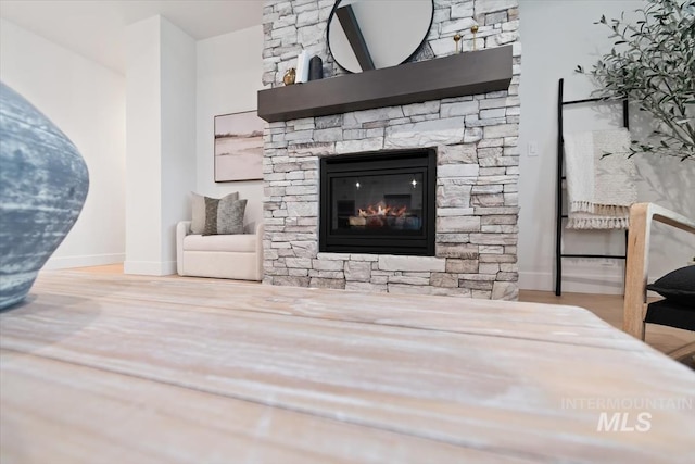 interior space with a fireplace, baseboards, and wood finished floors