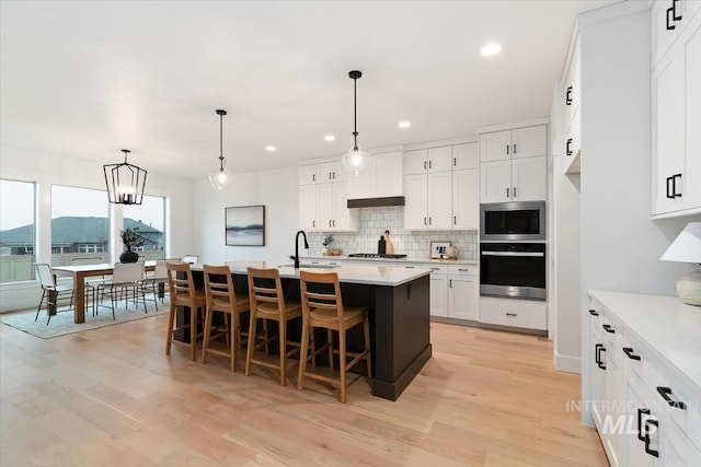 kitchen with a sink, light countertops, appliances with stainless steel finishes, and backsplash