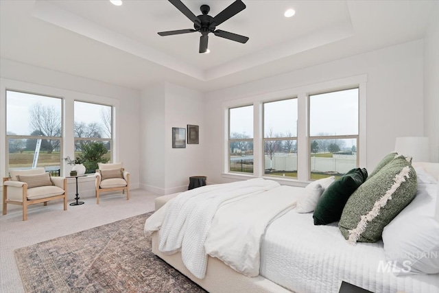 carpeted bedroom with a ceiling fan, recessed lighting, a raised ceiling, and baseboards