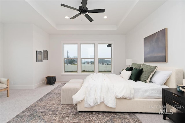 carpeted bedroom featuring a ceiling fan, a tray ceiling, baseboards, and recessed lighting