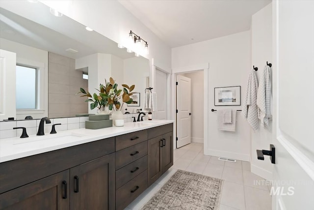 full bathroom featuring tile patterned flooring, visible vents, decorative backsplash, and a sink