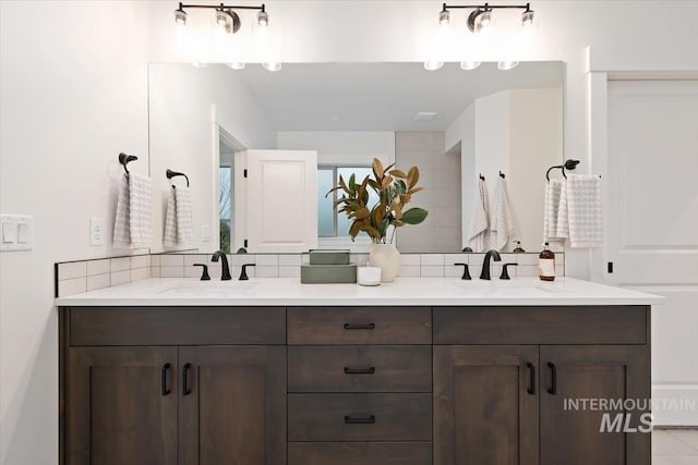 bathroom featuring double vanity, decorative backsplash, and a sink