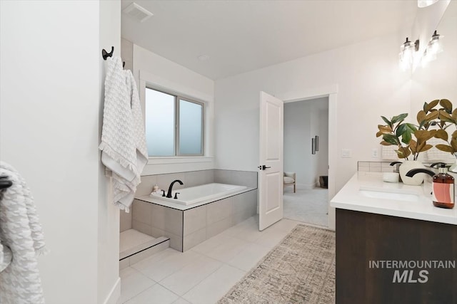 full bathroom with tile patterned flooring, a sink, visible vents, a bath, and double vanity