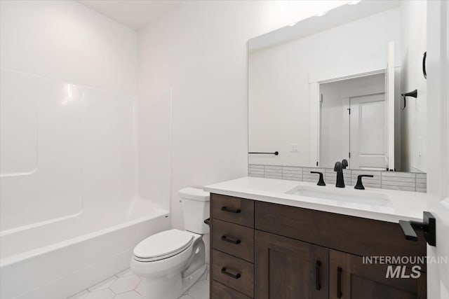 bathroom featuring washtub / shower combination, vanity, and toilet