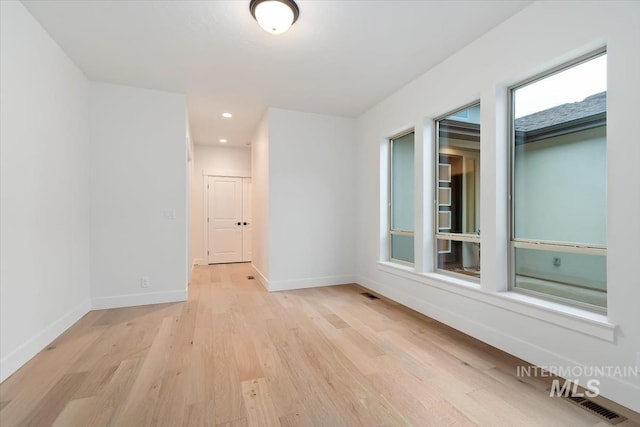 unfurnished room with light wood-style flooring, visible vents, baseboards, and recessed lighting