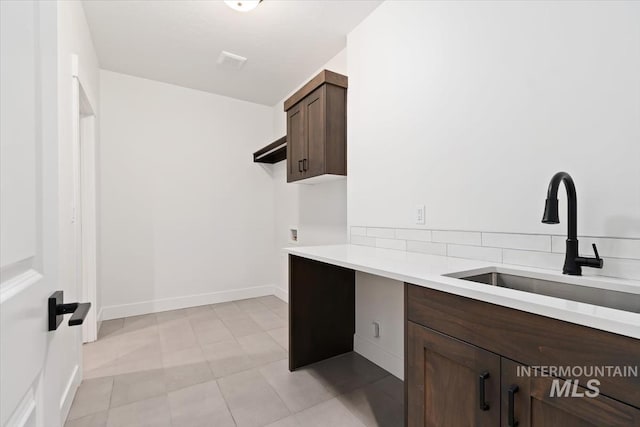 laundry area with washer hookup, a sink, visible vents, baseboards, and cabinet space