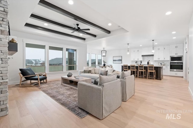 living area with light wood-style flooring, a ceiling fan, beam ceiling, and recessed lighting