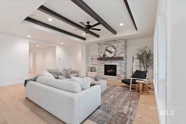 living room featuring a fireplace, recessed lighting, light wood-style flooring, beamed ceiling, and baseboards