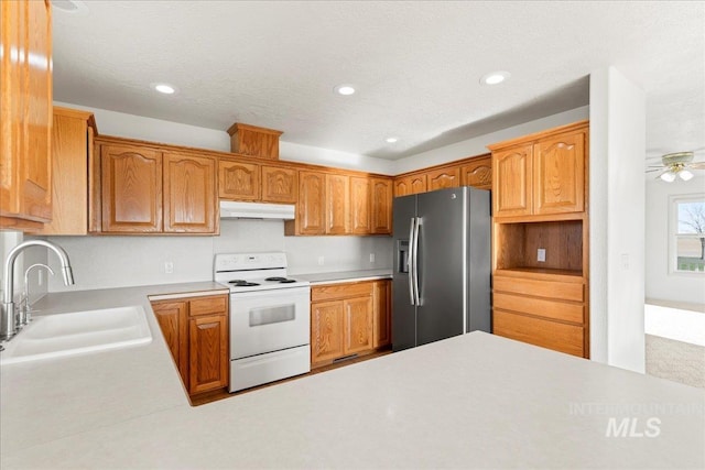 kitchen with under cabinet range hood, stainless steel fridge with ice dispenser, light countertops, a sink, and electric range