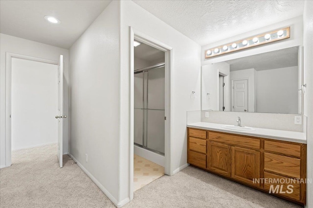 full bath featuring baseboards, an enclosed shower, vanity, and carpet