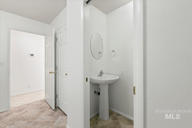 bathroom featuring stone finish flooring and baseboards