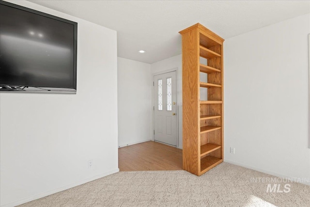 foyer entrance with carpet flooring and baseboards
