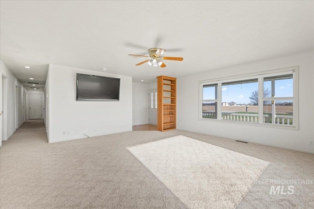 unfurnished living room featuring light colored carpet, a ceiling fan, visible vents, and recessed lighting