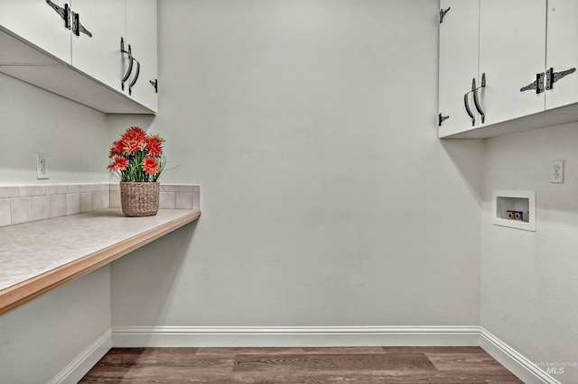 laundry room featuring hookup for a washing machine, dark wood-style flooring, cabinet space, and baseboards